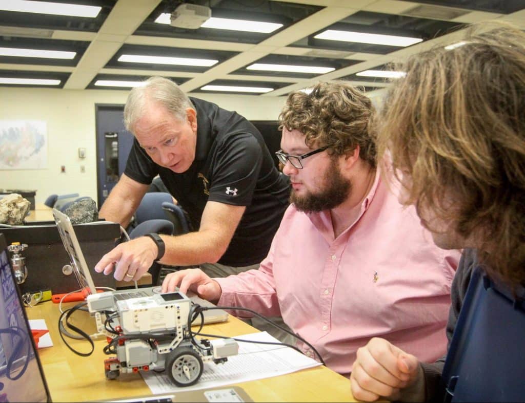 RMC computer science faculty member working with students on robotics project