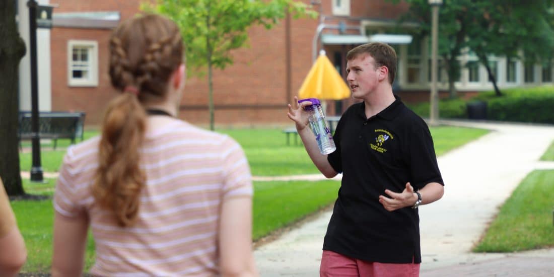 A student tour guide leads a group on a walk around the RMC campus.